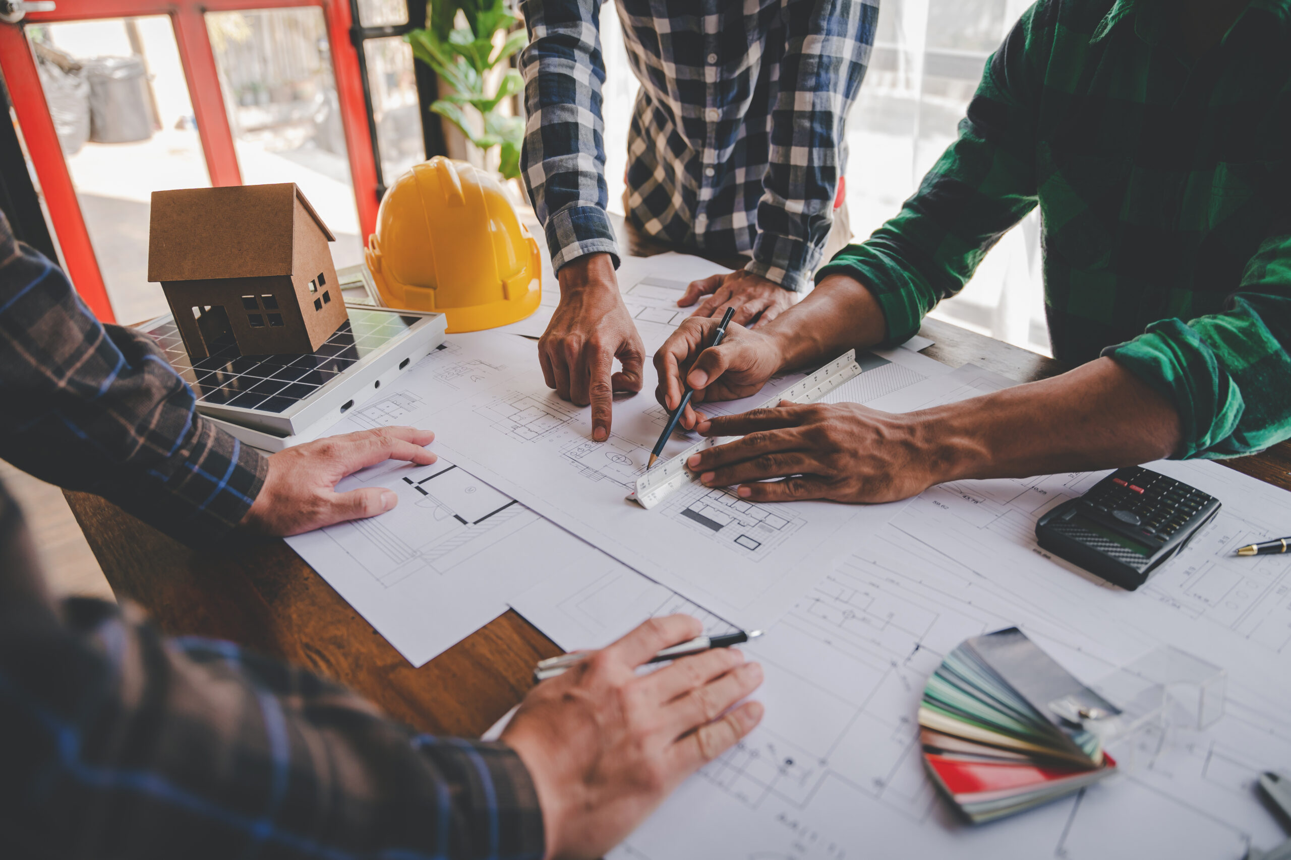 Engineers work as a team with blueprints for architectural plans